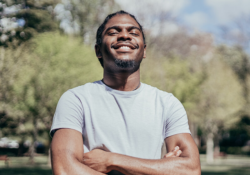 Man outside in the sun smiling because of continuing care