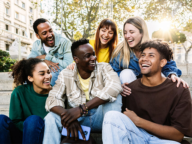 Community of Happy friends sitting next to each other in the city